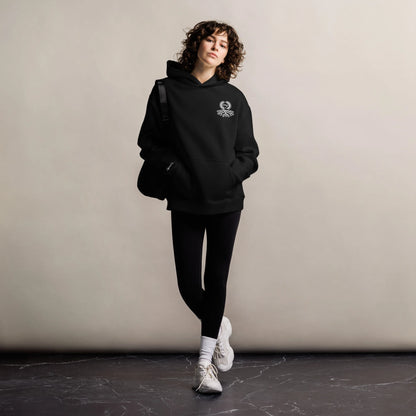Mujer con sudadera oversize negra Zaylachi Co. 319gsm de pie. Corte holgado hombros caídos streetwear unisex.
